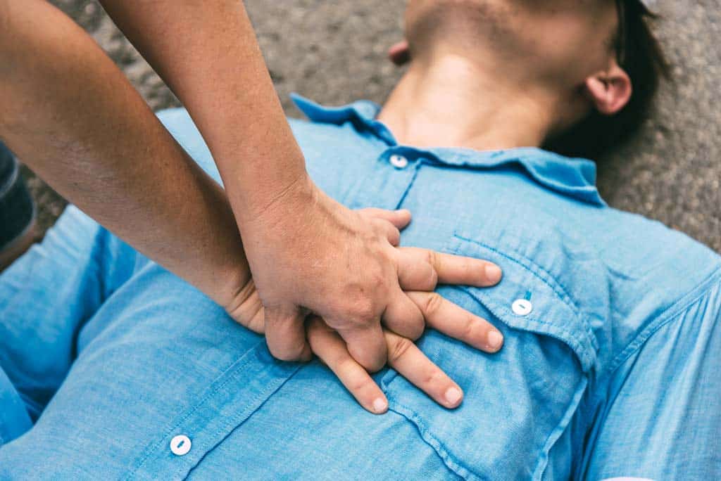 Hands doing chest compressions on a man